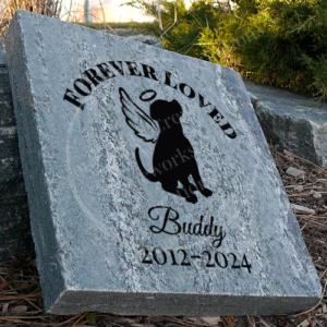 Engraved personalized granite pet memorial marker accent stone feature with "Forever Loved" and dog with halo, wings near walkway.