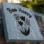 Engraved granite cottage/garden stone with bees and flowers design that says bee happy.