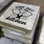 Engraved granite cottage/garden stone with pickleballs and paddles design that says stay out of the kitchen.